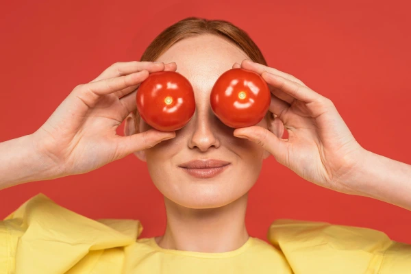 mulher segurando tomates um ingrediente perfeito para sucos detox